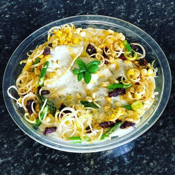 A healthy bowl from Eats Meets West Bowls with corn, asparagus, sun-dried tomatoes, and basil.