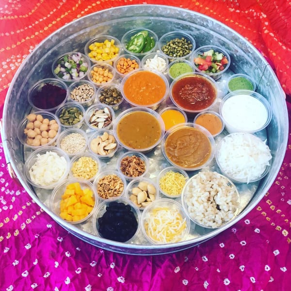 A large metal tray filled with small plastic containers of various healthy ingredients for custom bowls.